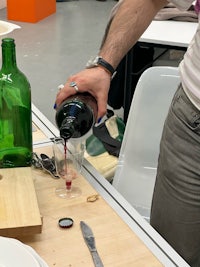 a man pouring wine into a glass on a table